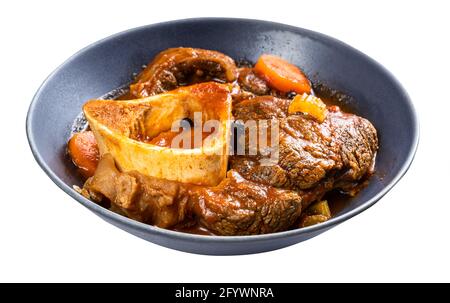 Portion Osso Buco (mit Gemüse, Wein und Brühe geschmortes Rindfleisch-Shin) in einer grauen Schüssel, isoliert auf weißem Hintergrund Stockfoto