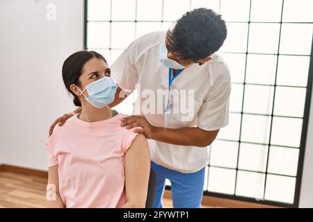 Junge Krankenschwester Mann legte Band Hilfe auf Frau Arm in der Klinik. Stockfoto