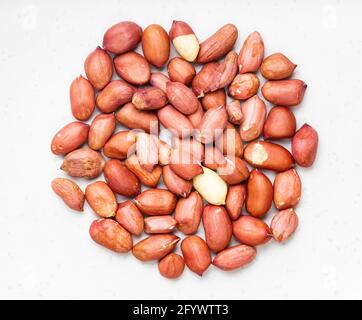 Draufsicht auf den Haufen geschälter Erdnüsse aus nächster Nähe Graue Keramikplatte Stockfoto