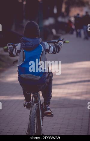 IASI, RUMÄNIEN - Mär 13, 2021: Ein junger Junge, der mit seinem Fahrrad einen Wheelie macht Stockfoto