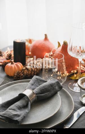 Halloween und Thanksgiving Tag Dinner dekoriert gefallenen Blättern, Kürbisse, Gewürze, grauen Teller. Nahaufnahme. Vertikales Format. Stockfoto