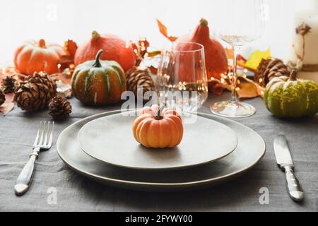 Halloween und Thanksgiving Tag Dinner dekoriert gefallenen Blättern, Kürbisse, Gewürze, grauen Teller. Nahaufnahme. Stockfoto