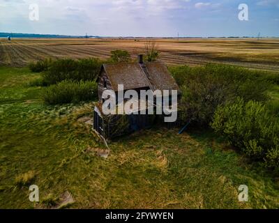 Luftaufnahme von alten verlassenen Bauernhäusern, die von der Natur zurückerobert wurden. Stockfoto