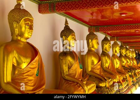 Skulpturen eines sitzenden Buddha in einer der vielen Galerien des buddhistischen Tempels von Wat Pho (Tempel des Reclining Buddha). Bangkok, Thailand Stockfoto