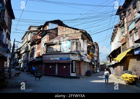 Srinagar, Indien. Mai 2021. Ein Mann mit Gesichtsmaske geht während einer Sperre durch einen geschlossenen Markt, die auferlegt wurde, um die Ausbreitung des Coronavirus in Srinagar zu verhindern. Die Regierung hat am Sonntag eine Lockerung der Lockdown-Richtlinien in Jammu und Kaschmir vom Montag an angeordnet, während die Bildungseinrichtungen bis zum 15. Juni geschlossen bleiben sollen. Indes verzeichnete Indien einen Tagesanstieg von 165,553 neuen COVID-19-Fällen, der niedrigste seit 46 Tagen mit 3,460 Todesfällen in den letzten 24 Stunden. Kredit: SOPA Images Limited/Alamy Live Nachrichten Stockfoto