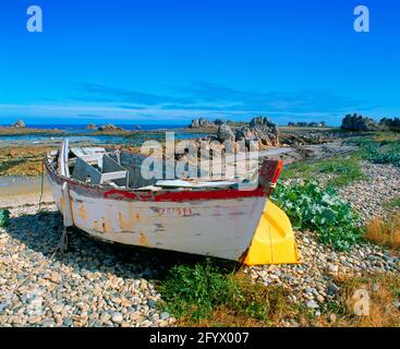 Frankreich, Bretagne, Cote d'Armor, felsige Küste, mit Fischerboot und Beiboot, Stockfoto