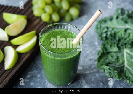 Entgiften Sie grünen Smoothie im Glas mit einem Bambusstroh, Nahaufnahme Stockfoto