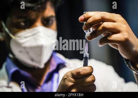 Kalkutta, Indien. Mai 2021. Ein Gesundheitsmitarbeiter bereitet sich darauf vor, einer Transgender-Person in einem Impfzentrum eine Dosis Kovishield-Impfstoff zu verabreichen. 50 Mitglieder der LGBTQ-Gemeinschaft in Kalkutta erhielten ihre erste Dosis Covishield-Impfstoff von einem Impfzentrum, das von Aktivisten von Techno India und Pranta Katha organisiert wurde. Kredit: SOPA Images Limited/Alamy Live Nachrichten Stockfoto