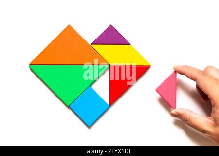 Farbe Holz Tangram Puzzle in Herzform warten zu erfüllen Auf weißem Hintergrund Stockfoto