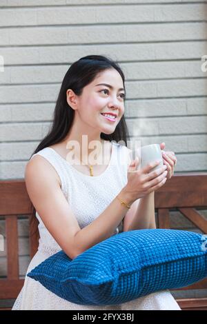 Lifestyle der schönen asiatischen Frau genießt frischen Kaffee am Morgen zu Hause. Glückliche Zeit des Stadtlebens. Stockfoto