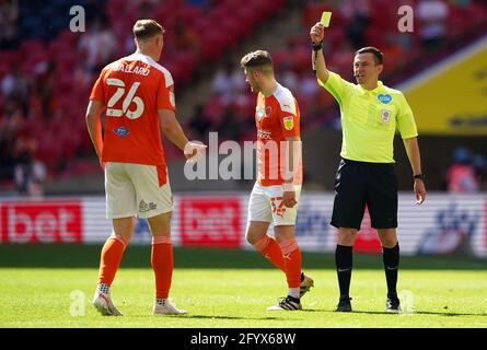 Schiedsrichter Tony Harrington (rechts) zeigt dem Blackpool-Spieler Daniel Ballard (links) während des Playoff-Finalmatches der Sky Bet League One im Wembley Stadium, London, eine gelbe Karte. Bilddatum: Sonntag, 30. Mai 2021. Stockfoto