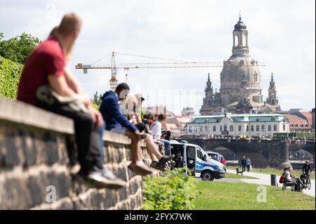 Dresden, Deutschland. Mai 2021. Passanten sitzen am Elbufer vor der Kulisse der Frauenkirche. Quelle: Sebastian Kahnert/dpa-Zentralbild/dpa/Alamy Live News Stockfoto