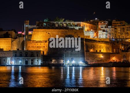 Valletta bei Nacht auf Malta, Stadtmauer Befestigungsanlagen und Upper Barrakka Gardens, Blick vom Grand Harbour. Stockfoto