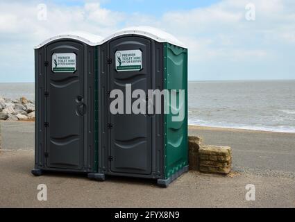 Zwei tragbare Kabinen an der Strandpromenade mit dem Meer im Hintergrund. Stockfoto