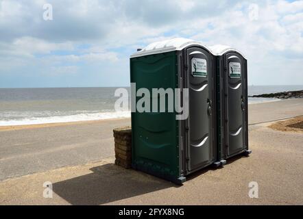 Zwei tragbare Kabinen an der Strandpromenade mit dem Meer im Hintergrund. Stockfoto