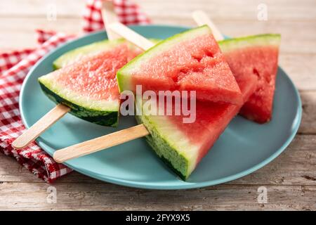 Wassermelone schneidet die Eiszapfen auf blauen Teller und Holztisch Stockfoto