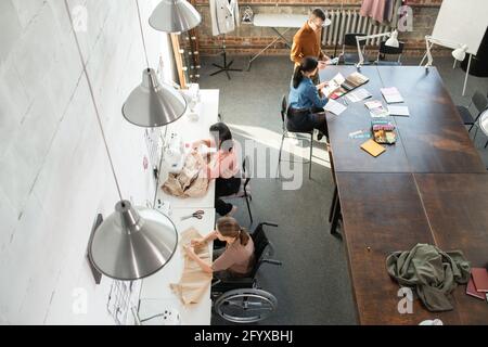 Zeitgenössische Schneider und kreative Modedesigner arbeiten in kleinen Gruppen Stockfoto