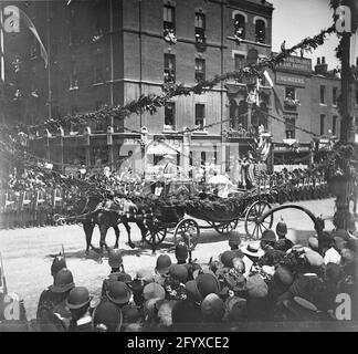 Zuschauer beobachten, wie die Kutsche von Königin Victoria (1819 - 1901) während der Prozession zum Diamantenjubiläum von Königin Victoria, London, England, am 22. Juni 1897 vorbeifährt. (Foto von Burton Holmes) Stockfoto