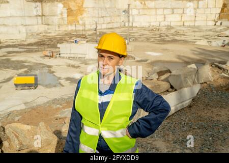 Reife weibliche Baumeisterin in Arbeitskleidung, die Sie auf Konstruktion anschaut Standort Stockfoto