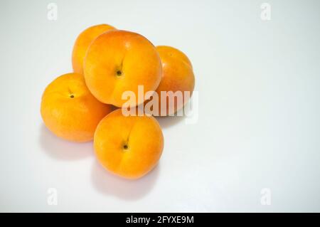 Spanische Aprikosen häufen sich. Isoliert über Weiß Stockfoto