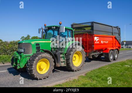 Traktor 6250R John Deere-Traktoren und zugehörige Landmaschinen die Ktwo Roadeo Curve-Serie von Kippsilage-Anhängern, die zum Schneiden von Gras in Cheshire, Großbritannien, verwendet werden Stockfoto