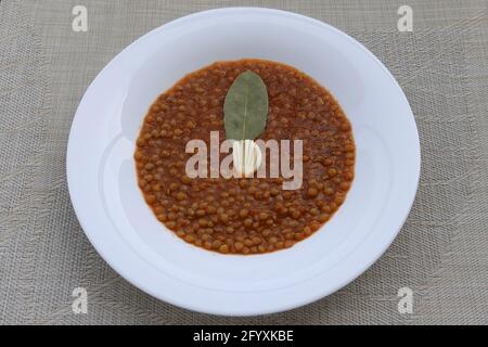 Linsensuppe mit Tomatensauce, Knoblauch und Lorbeerblatt. Griechisches Essen. Stockfoto