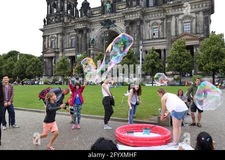 Ein Kind macht große Seifenblasen auf der Museumsinsel Stockfoto