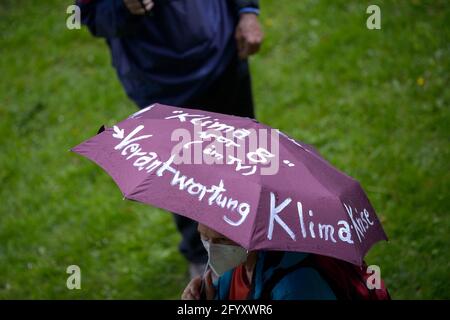 Hamburg, Deutschland. Mai 2021. Slogans über die Klimakrise sind auf den Schirm eines Demonstrators geschrieben. Verschiedene lokale Gruppen des Extinction Rebellion haben unter dem Motto "Klimakrise auf den Titelseiten" eine bessere Berichterstattung über die Klimakrise bei dezentralen Aktionen vor Medienhäusern gefordert. Quelle: Jonas Walzberg/dpa/Alamy Live News Stockfoto