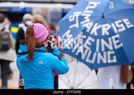 Hamburg, Deutschland. Mai 2021. Ein Fotograf fotografiert einen Regenschirm bei der Extinction Rebellion Rallye. Verschiedene lokale Gruppen des Extinction Rebellion haben unter dem Motto "Klimakrise auf den Titelseiten" eine bessere Berichterstattung über die Klimakrise bei dezentralen Aktionen vor Medienhäusern gefordert. Quelle: Jonas Walzberg/dpa/Alamy Live News Stockfoto