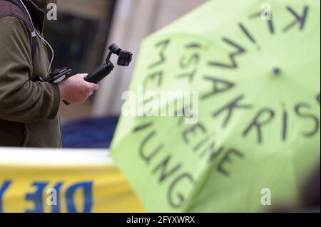 Hamburg, Deutschland. Mai 2021. Ein Reporter filmt die Extinction Rebellion Rallye mit seiner Kamera. Verschiedene lokale Gruppen des Extinction Rebellion haben unter dem Motto "Klimakrise auf den Titelseiten" eine bessere Berichterstattung über die Klimakrise bei dezentralen Aktionen vor Medienhäusern gefordert. Quelle: Jonas Walzberg/dpa/Alamy Live News Stockfoto