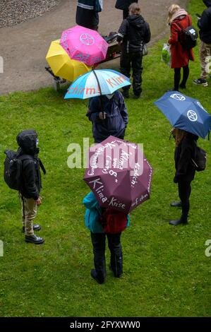 Hamburg, Deutschland. Mai 2021. Auf den Regenschirmen der Demonstranten stehen Parolen über die Klimakrise. Verschiedene lokale Gruppen des Extinction Rebellion haben unter dem Motto "Klimakrise auf den Titelseiten" eine bessere Berichterstattung über die Klimakrise bei dezentralen Aktionen vor Medienhäusern gefordert. Quelle: Jonas Walzberg/dpa/Alamy Live News Stockfoto