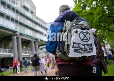 Hamburg, Deutschland. Mai 2021. Ein Demonstrator hat ein Extinction Rebellion Logo an seinem Rucksack angebracht. Verschiedene lokale Gruppen des Extinction Rebellion haben unter dem Motto "Klimakrise auf den Titelseiten" eine bessere Berichterstattung über die Klimakrise bei dezentralen Aktionen vor Medienhäusern gefordert. Quelle: Jonas Walzberg/dpa/Alamy Live News Stockfoto