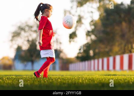 Mädchen kicks einen Fußball auf einem Fußballfeld Stockfoto