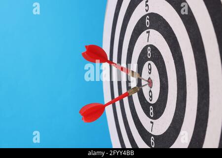 Darts in der Mitte mit Darts auf blauem Hintergrund. Stockfoto