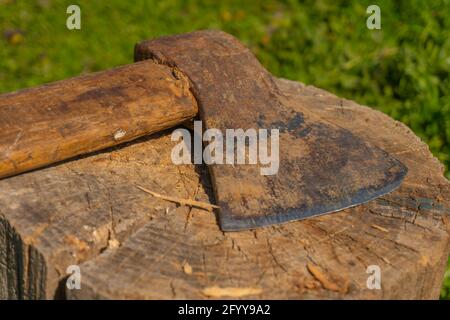 Eine rostige Axt liegt auf einem Baumstumpf Stockfoto