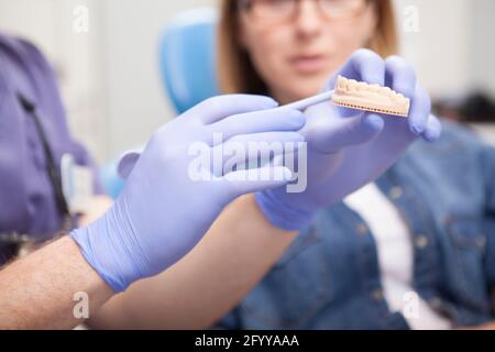 Nahaufnahme einer Zahnform in den Händen von Zahnarzt Stockfoto
