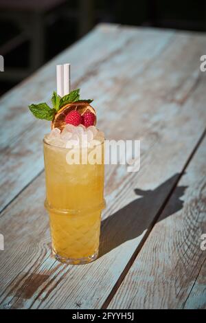 Ein Glas kalter Rum und ein Cocktail aus Orangensaft sind mit dekoriert Getrocknete Zitrusfrüchte auf dem Tisch am Sommertag Stockfoto