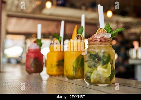 Eine Auswahl an erfrischenden verschiedenen Mojito-Cocktails, darunter Erdbeerpfirsich und Klassische Gerichte werden an der Bar serviert Stockfoto