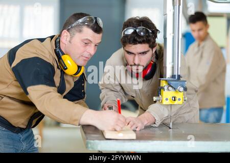 Portrait von Zimmerleuten, die Holz schneiden Stockfoto