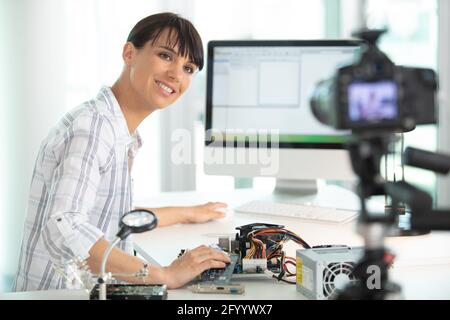 Junge attraktive Bloggerin oder Vlogger beim Betrachte der Kamera Stockfoto