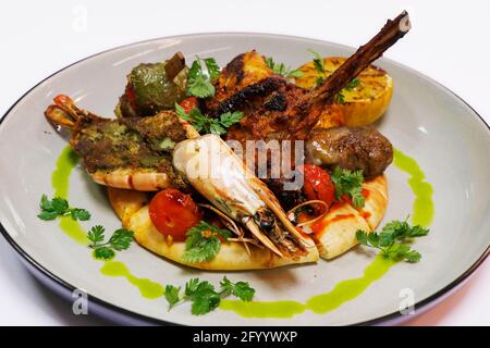 gegrillte Meeresfrüchte im arabischen Stil und eine Fleischplatte mit Garnelen, Lamm, Rind, Huhn auf Fladenbrot Stockfoto