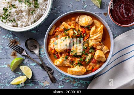 Köstlicher brasilianischer Fisch-Eintopf Moqueca mit Tomaten, Limette, rotem Pfeffer, Kokosmilch und Koriander. Stockfoto