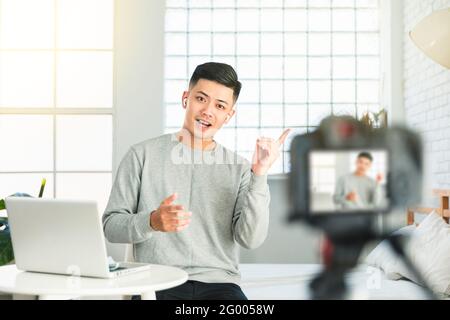 Junger Mann, der Video für eine Internet-tv-Show aufzeichnet oder Tutorial-Streaming Stockfoto