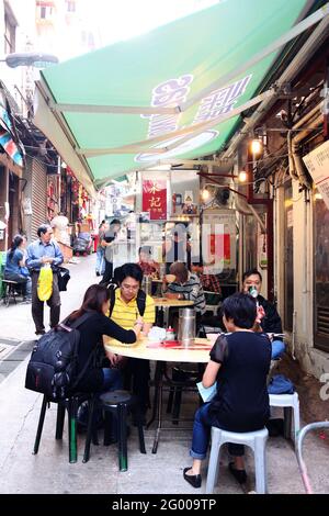 HONGKONG – APR. 19, 2011: Mittags essen die Leute an den Open-Air-Straßenständen, die als Dai Pai Dong im Zentrum von Hongkong bekannt sind. Diese Außenküchen sind Stockfoto