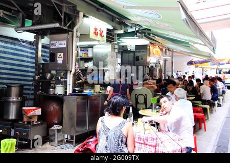 HONGKONG – APR. 19, 2011: Mittags essen die Leute an den Open-Air-Straßenständen, die als Dai Pai Dong im Zentrum von Hongkong bekannt sind. Diese Außenküchen sind Stockfoto