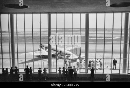 Besucher beobachten Flugzeuge durch das Fenster des Hauptwarterraums auf dem städtischen Flughafen in Washington, DC, Juli 1941 Stockfoto