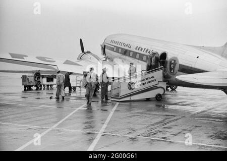 Passagiere, die an einem regnerischen Tag auf dem städtischen Flughafen in Washington, DC, ein Flugzeug besteigen, Juli 1941 Stockfoto