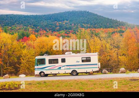 Ein älteres Class A-Wohnheim, das während der brillanten Herbstsaison auf einer Straße in den Green Mountains, Adirondack-Kette, geparkt wurde. USA. Stockfoto