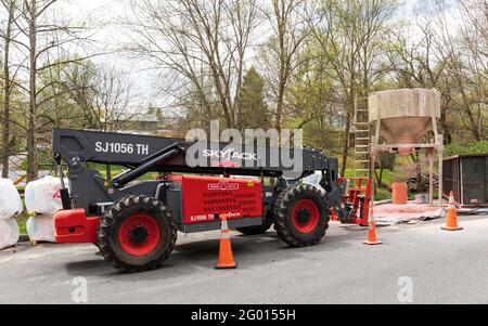 JONESBOROUGH, TN, USA--9. APRIL 2021: Industrielle Baumaschinen, einschließlich eines „Skyjack“-Aufzugs und eines Mörtelmischers. Stockfoto