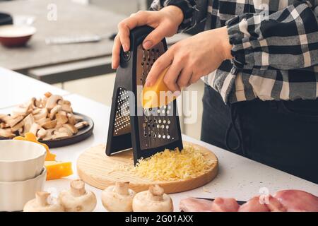 Frau Gitter Käse in Küche Stockfoto